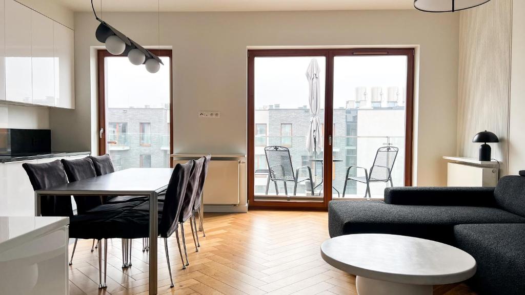 a living room with a couch and a table and chairs at Luxe Downtown Dwellings in Krakow