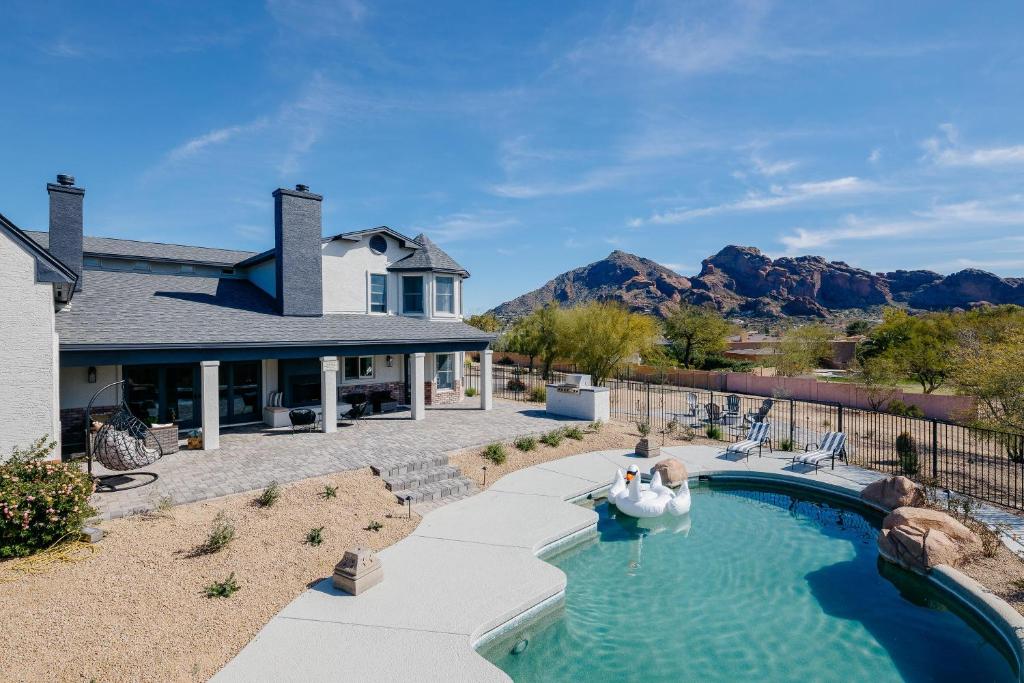 a house with a swimming pool and a house at Majestic Mountain Mansion - Camelback Views! in Scottsdale
