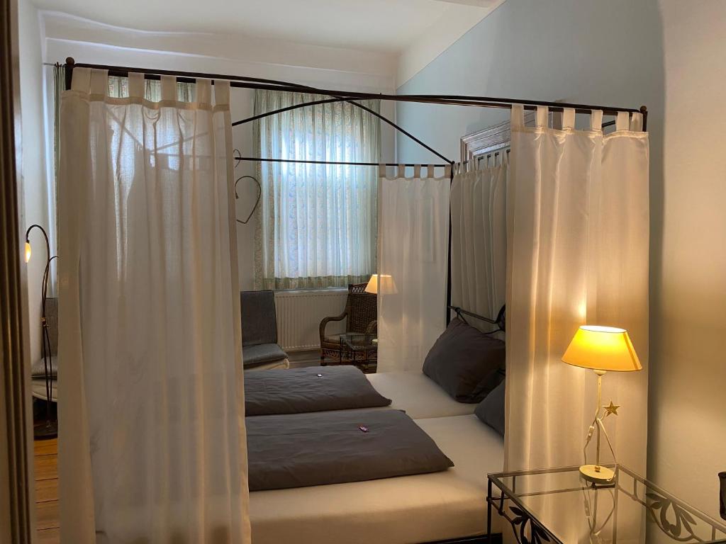 a bedroom with a four poster bed with curtains at Hotel Weinstube am Markt in Gerolzhofen