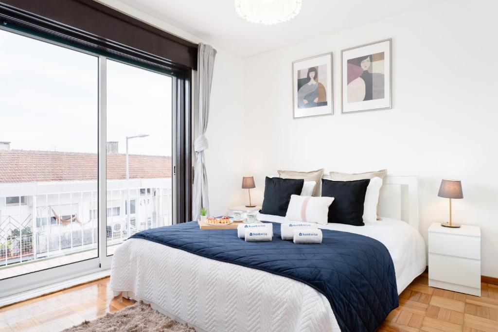 une chambre avec un grand lit et une grande fenêtre dans l'établissement Host Wise - Spacious Sunny House with terrace & BBQ, à Vila Nova de Gaia