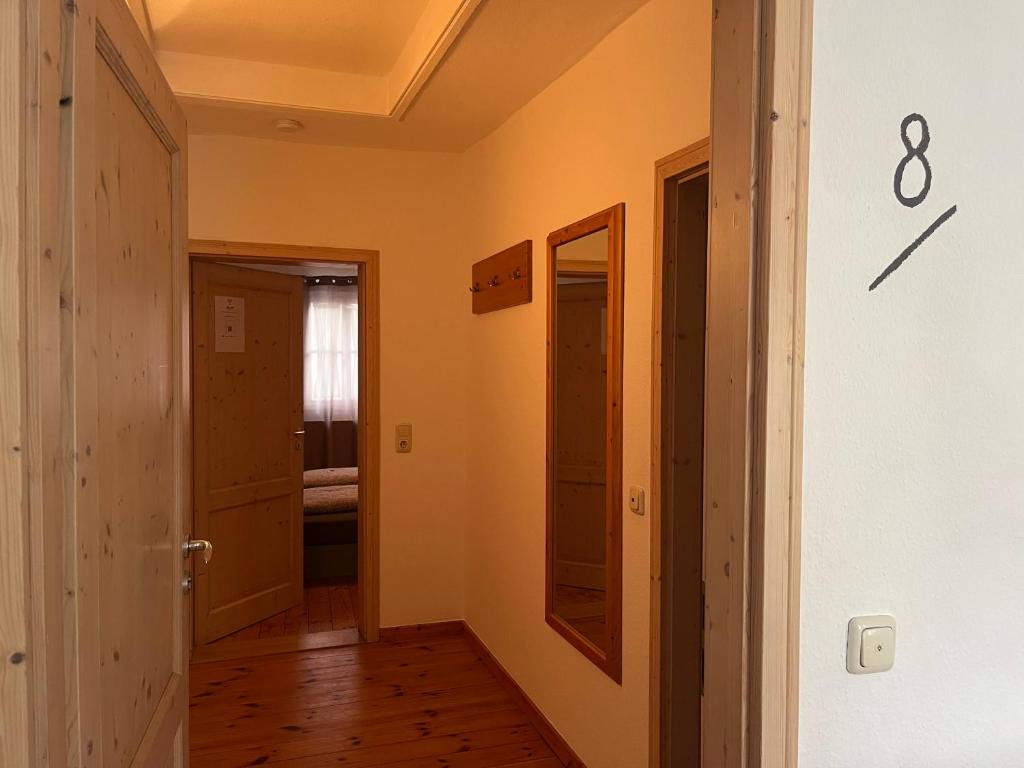 a hallway with a door and a clock on the wall at Hotel Weinstube am Markt in Gerolzhofen