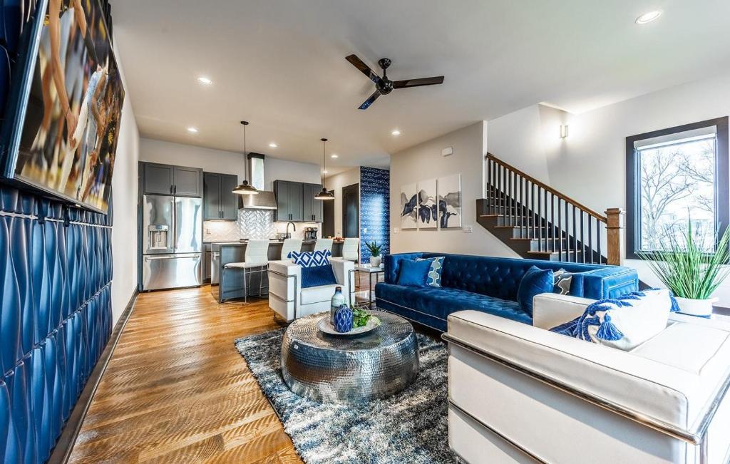 ein Wohnzimmer mit einem blauen Sofa und einer Küche in der Unterkunft Nashville Blues - Walk to Gulch - Rooftop Views of Downtown in Nashville