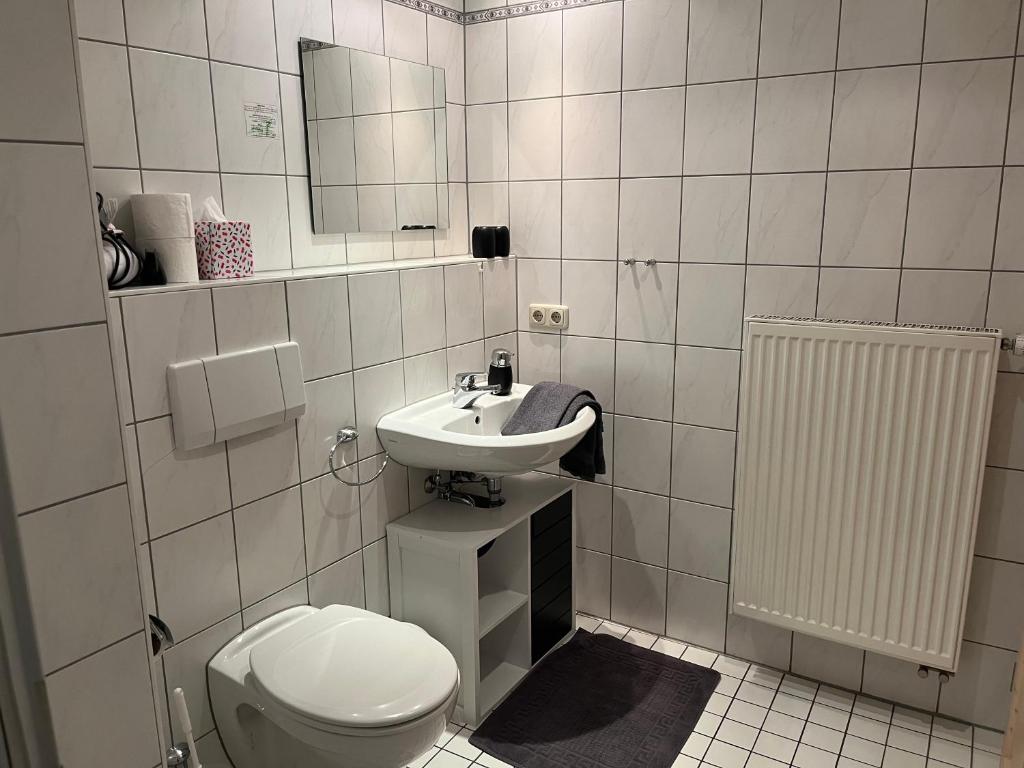 a white bathroom with a toilet and a sink at Hotel Weinstube am Markt in Gerolzhofen