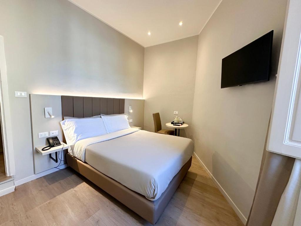 1 dormitorio con 1 cama y TV de pantalla plana en Hotel Giappone - 2 Min Walk Duomo of Florence en Florence