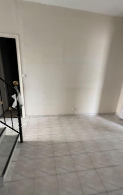 Camera con pareti bianche e pavimento piastrellato. di Maison entière équipée 220m2 a Clamart