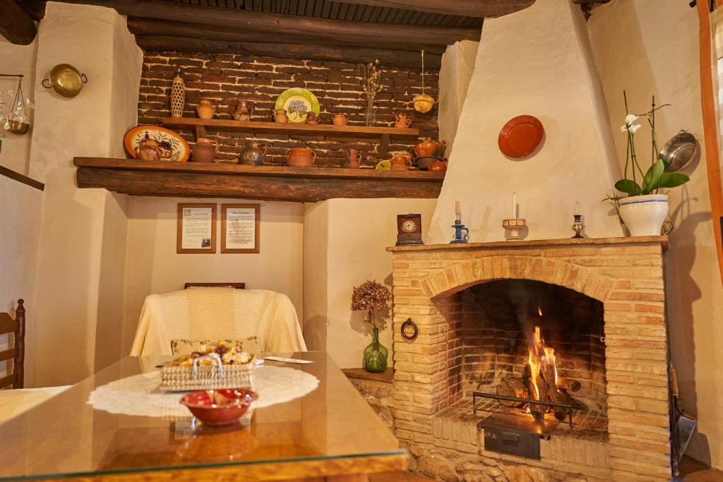 sala de estar con chimenea y mesa en Zarzo del Tragaluz, en Fuenteheridos