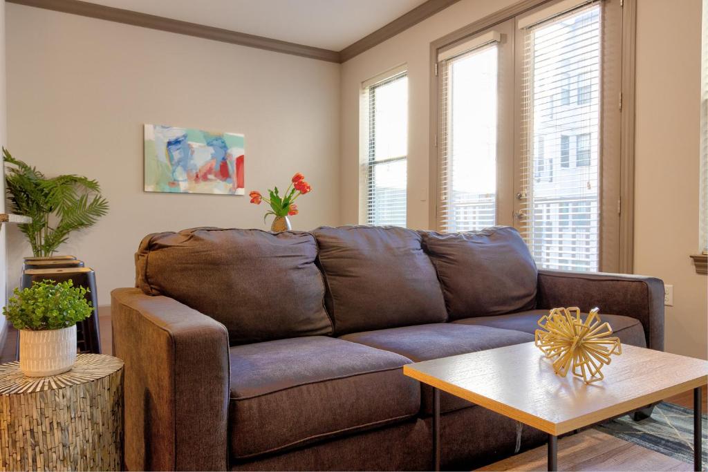 a living room with a brown couch and a table at Kasa Central West End St Louis in Maryland Heights