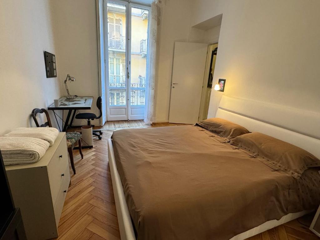 a bedroom with a bed and a desk and a window at La Casa di Titilla in Turin