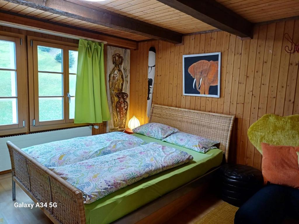 a bedroom with a bed in a room with wooden walls at Afrika Zimmer mit Bergblick in Emmetten