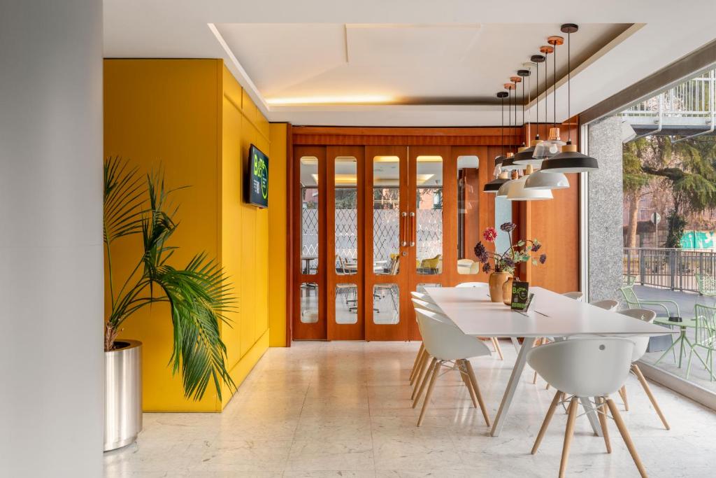 une salle à manger avec une table blanche et des murs jaunes dans l'établissement B&B Hotel Modena, à Modène