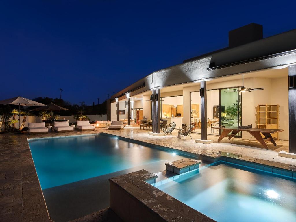 a swimming pool in front of a house at night at Hillside Mansion-Pool/Cold Plunge/Sauna-Mtn Views in Scottsdale