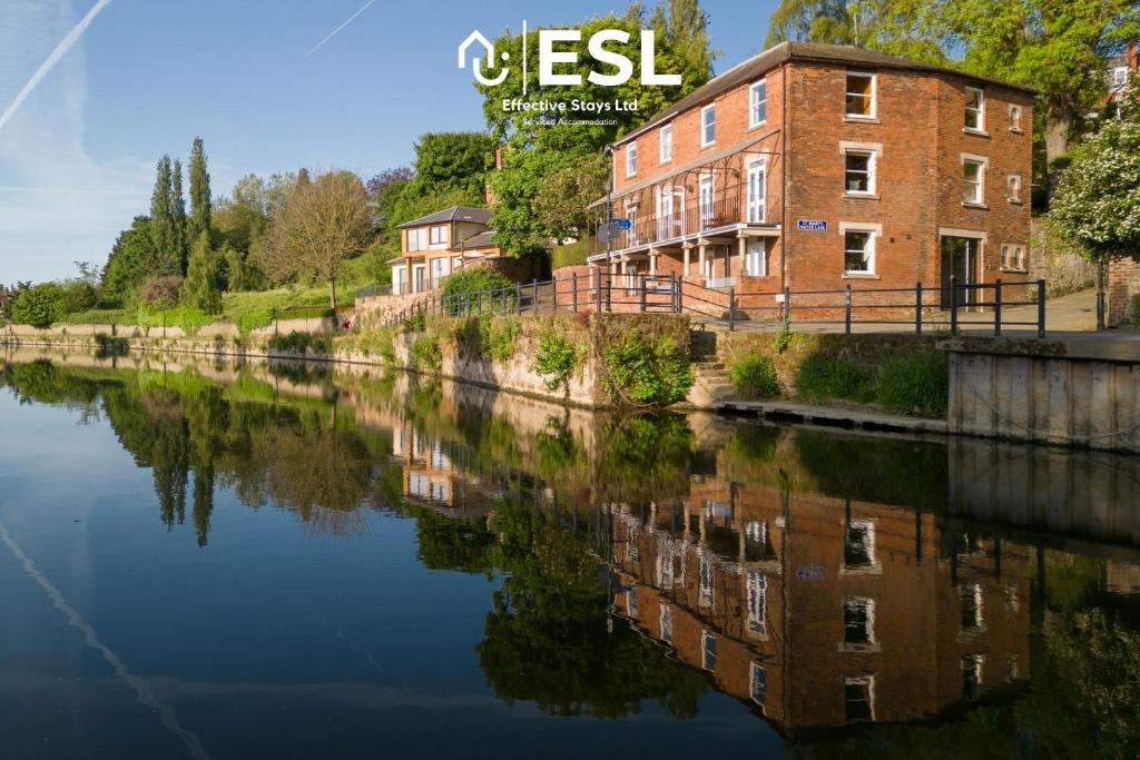 a building on the side of a river at 3 Bedroom House - Overlooking River - Shrewsbury Town Centre in Shrewsbury