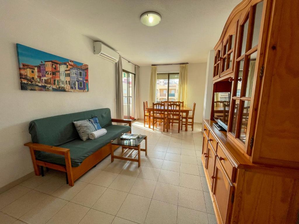 ein Wohnzimmer mit einem Sofa und einem Tisch in der Unterkunft Apartamentos Entreplayas 3000 in Oropesa del Mar