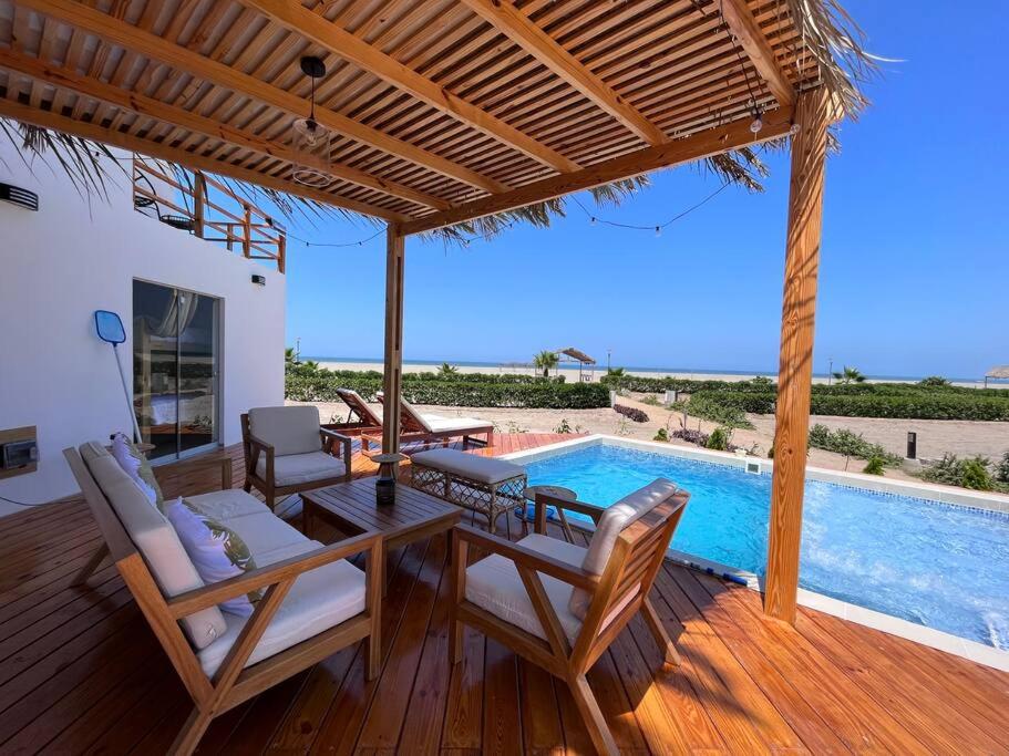 a patio with a table and chairs and a swimming pool at Infinity Chincha Casa de Playa y Piscina in Casa Blanca