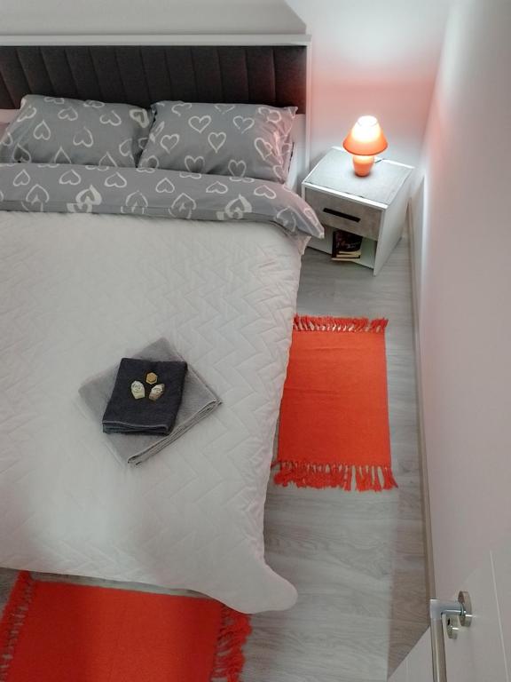 a small bedroom with a bed with a red rug at Apartman Plaza 9 in Veliko Gradište