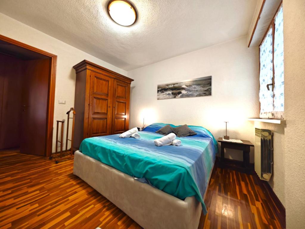 a bedroom with a bed with two towels on it at Hostdomus - Wood Apartment in Cesana Torinese
