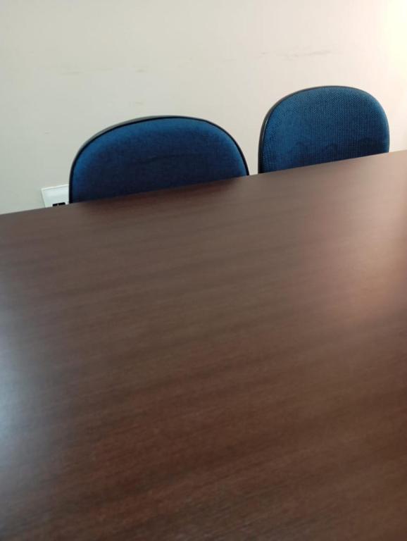 a wooden conference table with blue chairs in an office at Ap Guaruja pitangueira 50m praia in Guarujá