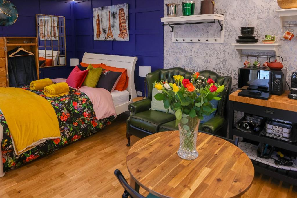 1 dormitorio con mesa y jarrón de flores en Le Chic Retreat - Luxury Hot Tub Getaway, en Bournemouth