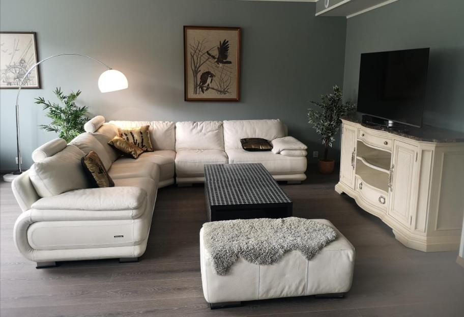 a living room with a white couch and a tv at Apartment Isfjordsveien in Åndalsnes
