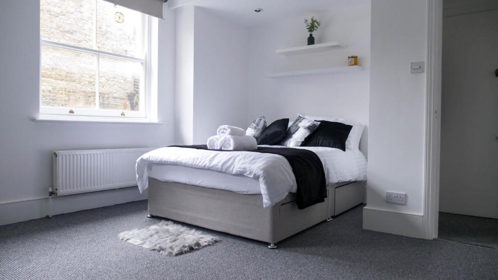 a bedroom with a bed with a teddy bear on it at Modern Apartment in Shoreditch, City Centre in London