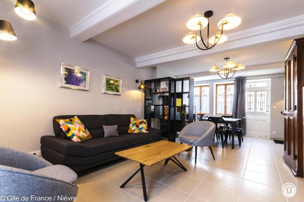 a living room with a couch and a table at Le gîte de la poste in Onlay