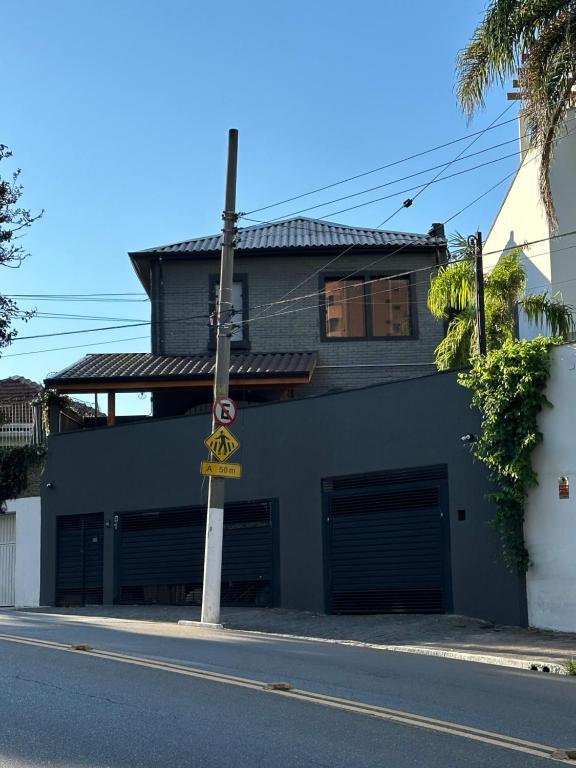 a building with two garage doors on a street at A CASINA: STUDIOS Vila Madalena - BECO DO BATMAN in Sao Paulo
