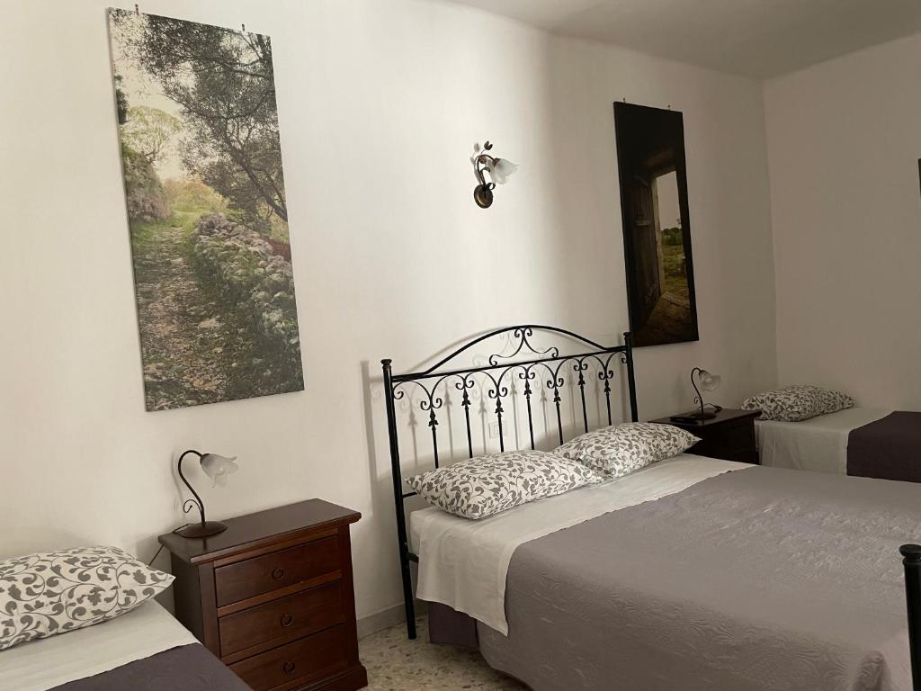 プティニャーノにあるArco Micheleのベッドルーム1室(ベッド2台、鏡付)