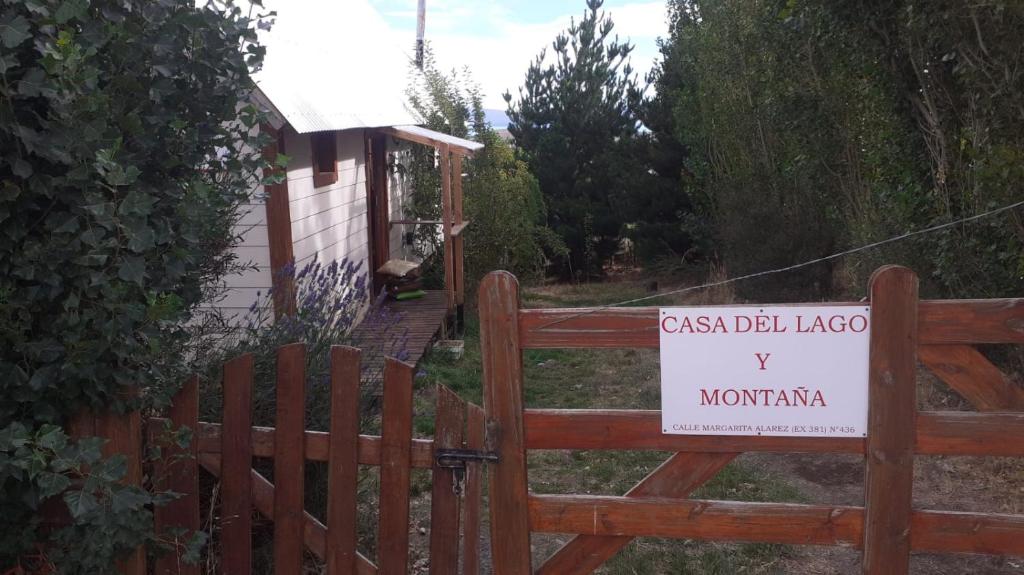 a wooden gate with a sign in front of a house at Casa de Lago y Montaña in El Calafate
