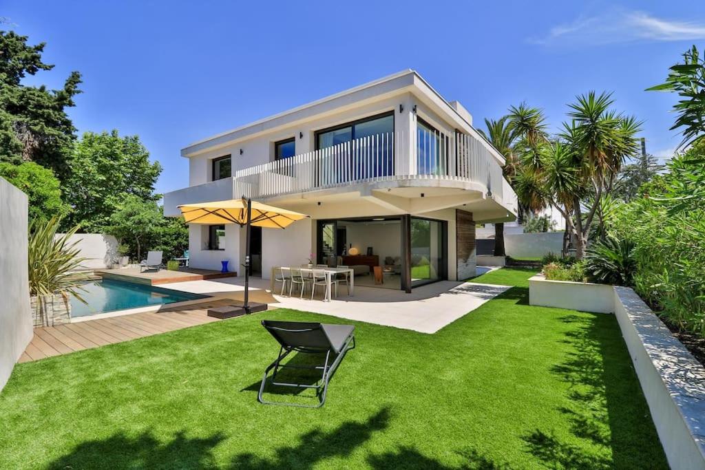 une maison avec une pelouse et une piscine dans l'établissement Superbe villa moderne avec piscine à Marseille - Villa Marseilleveyre, à Marseille