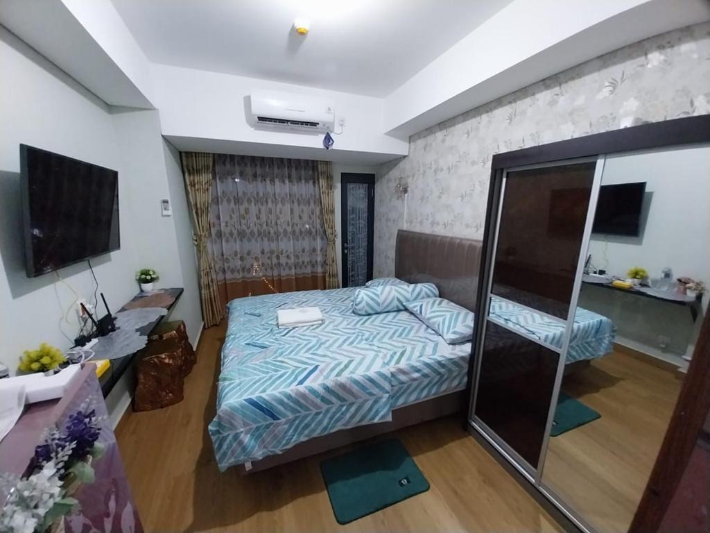 - une chambre avec un lit et une télévision dans l'établissement Sri Studio 07@Pollux Habibie Meisterstadt, à Batam Center