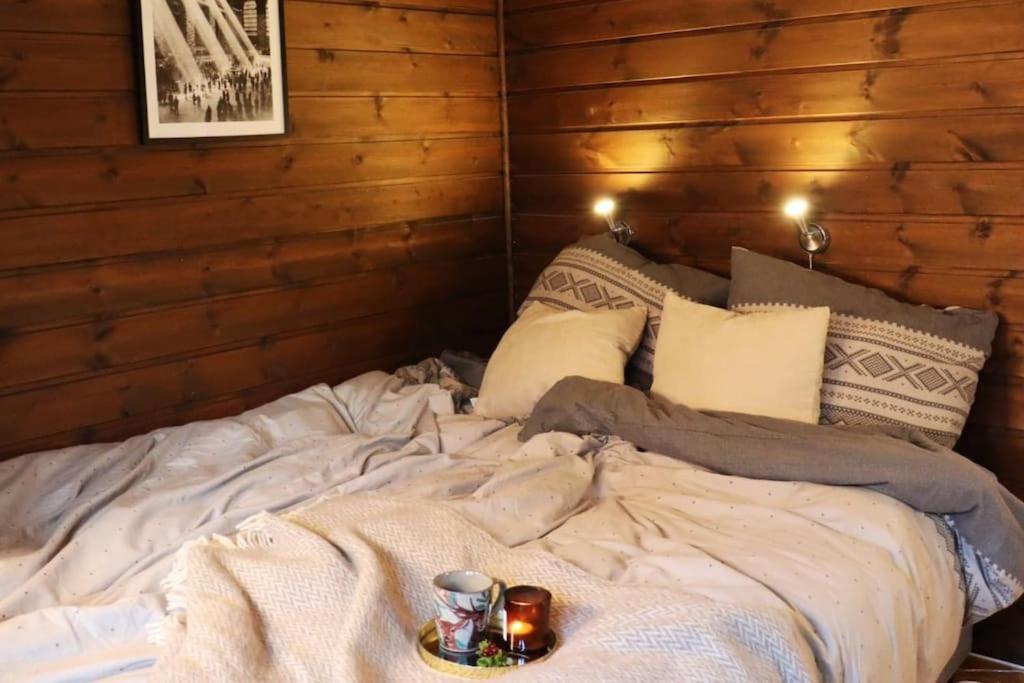 een groot bed met een dienblad met eten erop bij Familiehytte på Beito in Beitostøl
