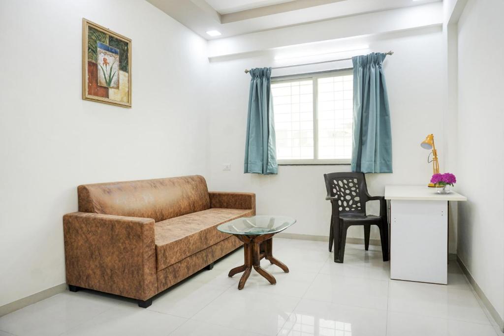 sala de estar con sofá y mesa en Collection O Hotel Galaxy Executive, en Kharadi