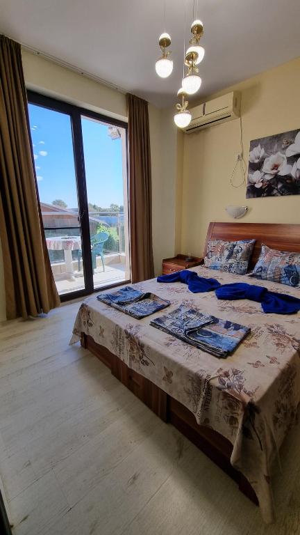 a bedroom with a large bed with a large window at Apartment Pool in Sinemorets