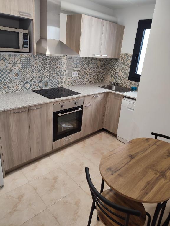 a kitchen with a wooden table and a wooden table and a table and a kitchen at La Quadra de Quelo 3 in Àger