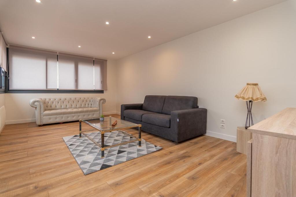 a living room with a couch and a chair at Le Pied à Terre de Montcenis - Appt avec parking privé in Montcenis