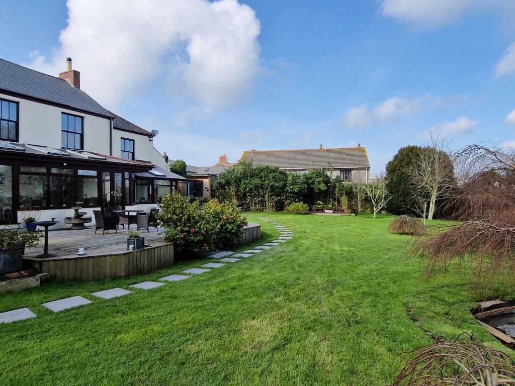 a yard with a house and a lawn with a patio at The Cedars in Redruth