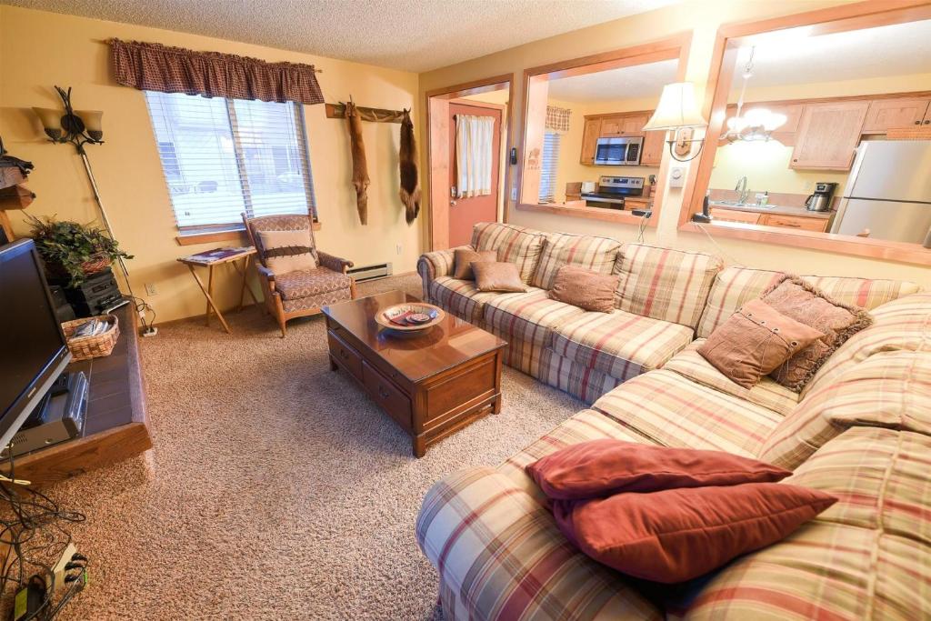 - un salon avec un canapé et une table dans l'établissement Trapper Condo Unit 3, à West Yellowstone