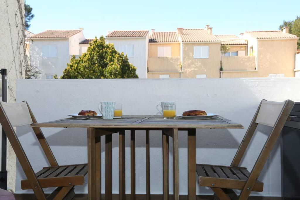 einen Tisch mit 2 Tellern Essen auf einem Balkon in der Unterkunft Appartement Lavande YourHostHelper in Saint-Cyr-sur-Mer