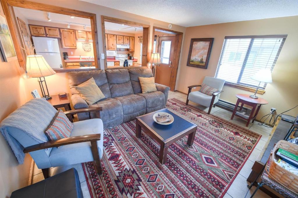 ein Wohnzimmer mit einem Sofa und einem Tisch in der Unterkunft Trapper Condo Unit 5 in West Yellowstone