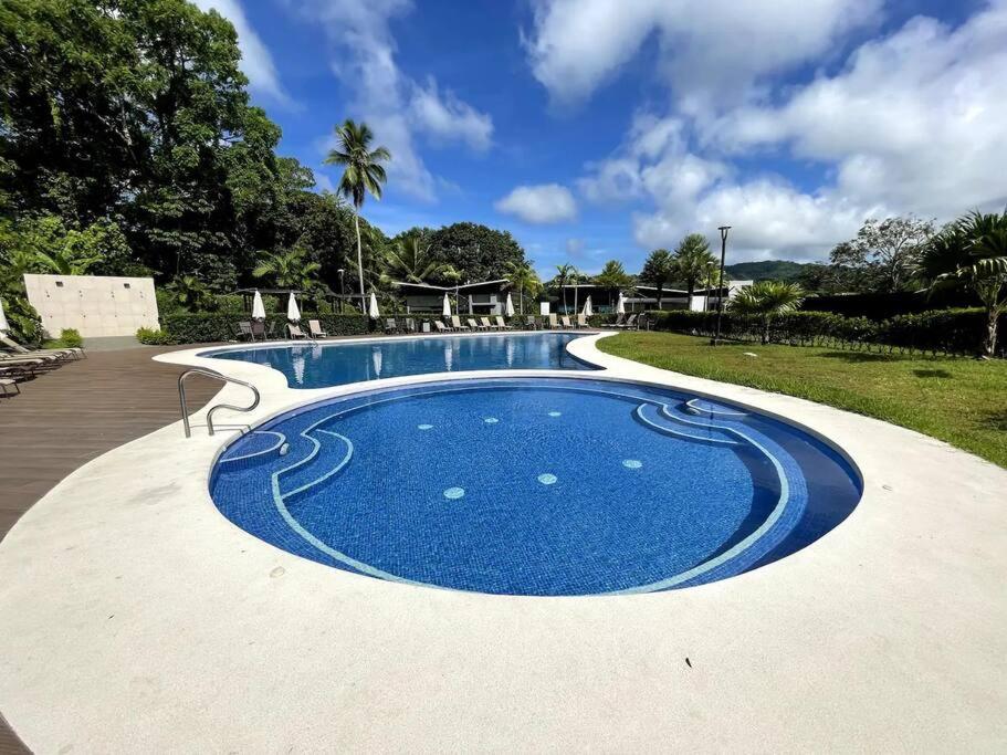 a large swimming pool with a blue at Jaco Beach Villa Arenas Condo in Jacó