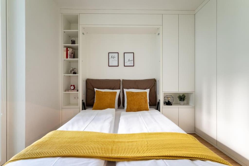 um quarto com uma cama grande e almofadas amarelas em HM • New Studio by WU & Messe em Viena