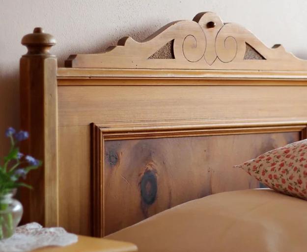 a wooden headboard of a bed in a bedroom at Bio Ferienbauernhof Greber in Schwarzenberg