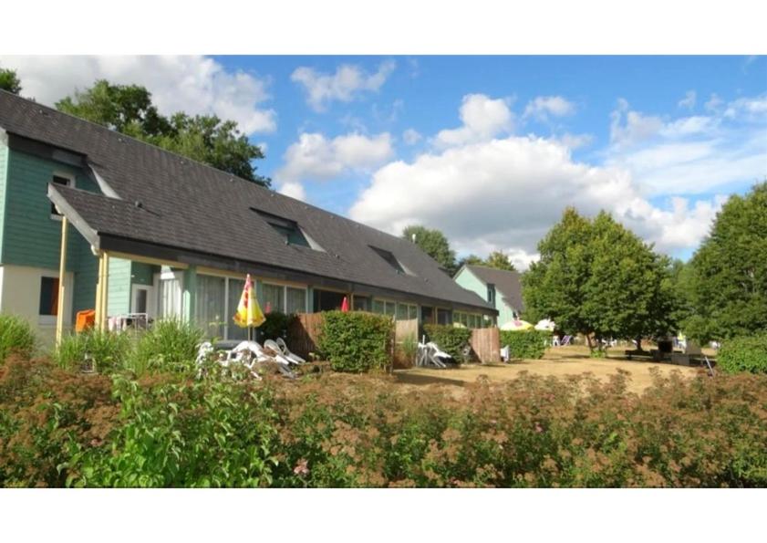 a house with a garden in front of it at Le village de Sèchemailles in Ambrugeat