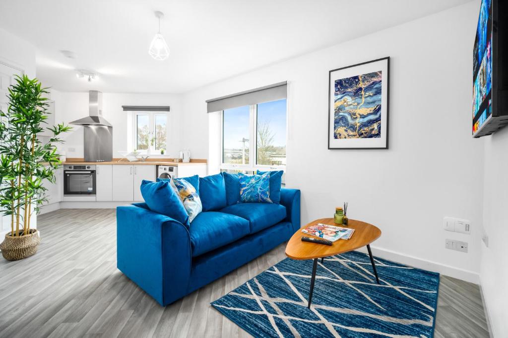 uma sala de estar com um sofá azul e uma mesa em 2 Bedroom Deluxe Apt - Off-Street Parking - Wifi - Netflix - 57C em Sleightholme