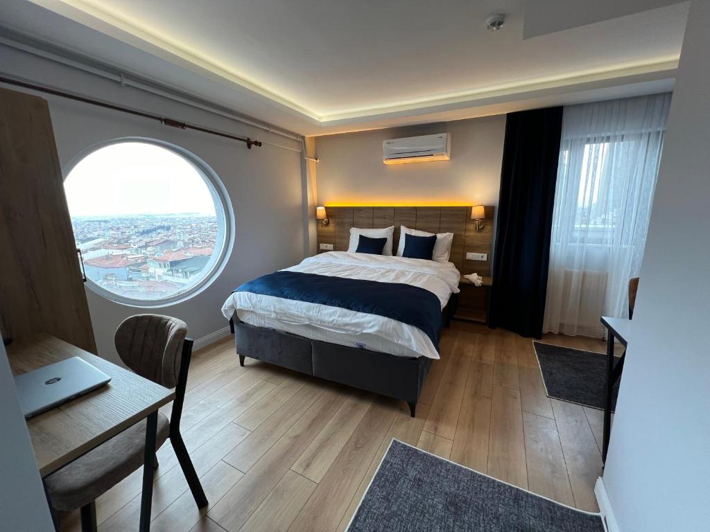 1 dormitorio con cama, escritorio y ventana en The Blue Suites en Estambul