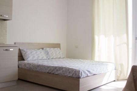 uma cama num quarto branco com uma janela em Center Boa Vista em Sal Rei