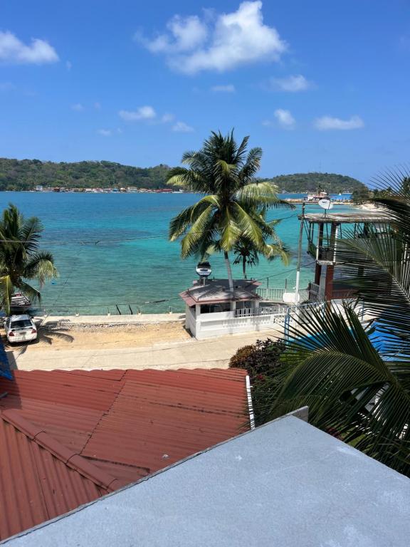 vistas a una playa con palmeras y al océano en KingFish en Colón