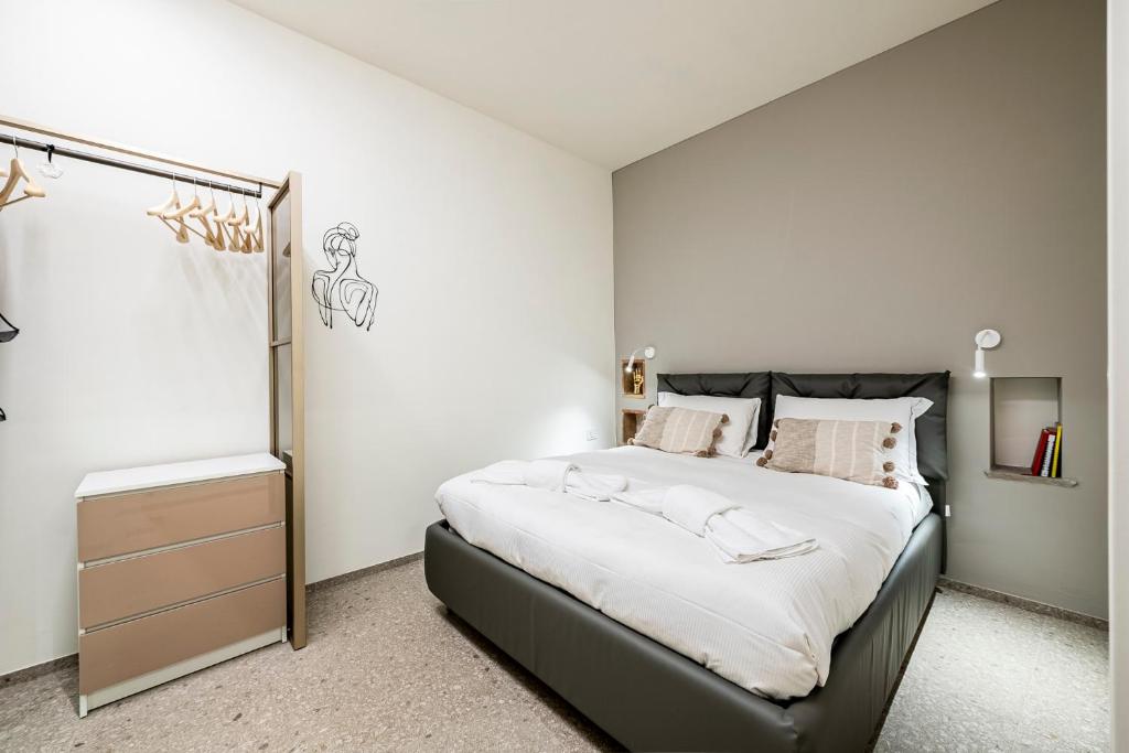 una camera da letto con un grande letto e pareti bianche di Rifugio99 Firenze - Giardini di Boboli a Firenze