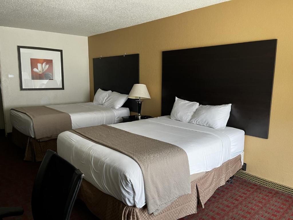 a hotel room with two beds and a lamp at Budget Inn Laramie in Laramie