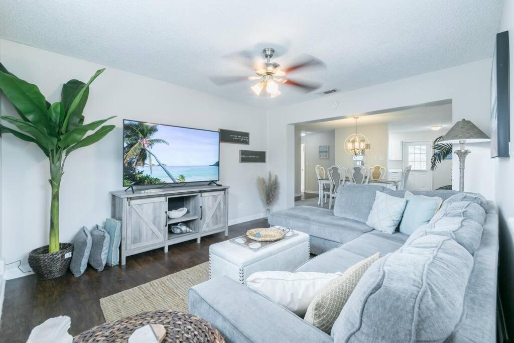 a living room with a blue couch and a tv at Fun 5* Hot Tub/Beaches getaway Near MAYO in Jacksonville